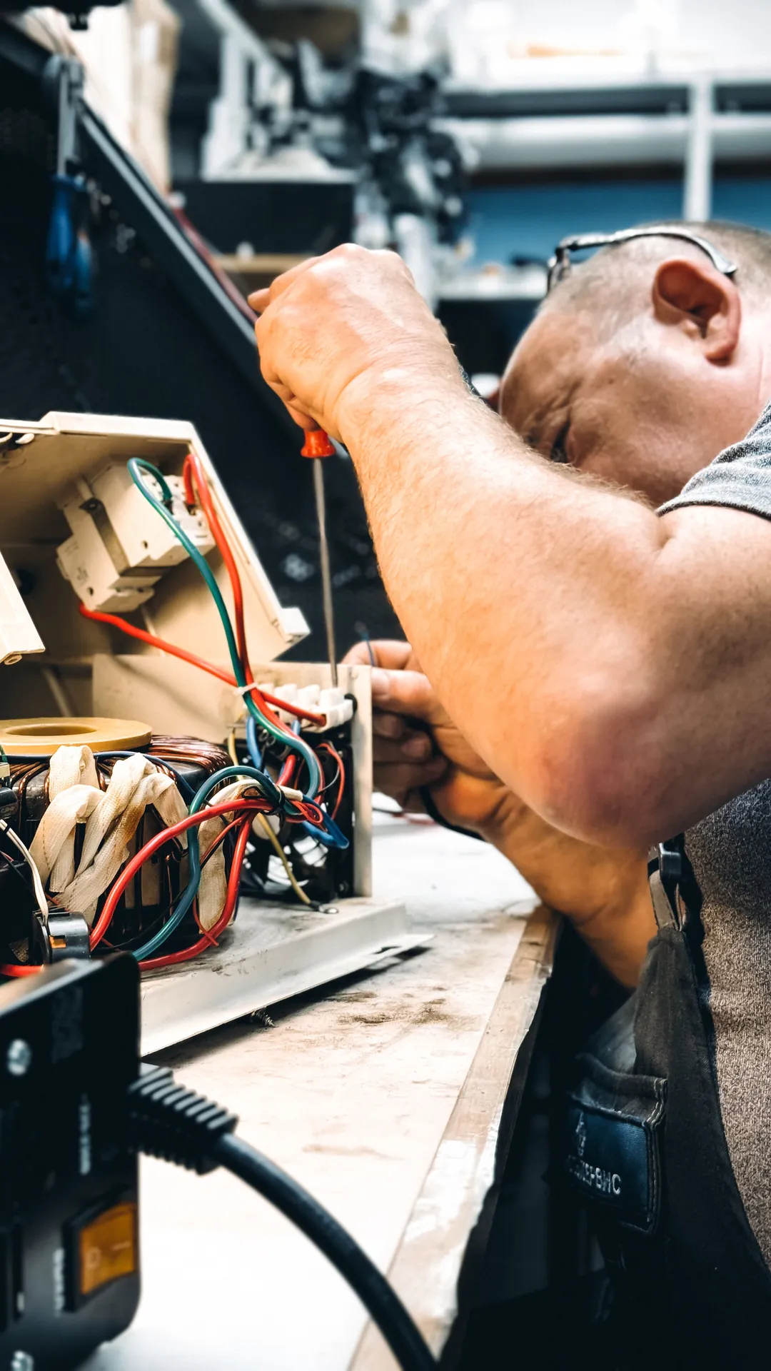 Close-up of hands adjusting a boiler system with precise instrumentation, showing maintenance work.